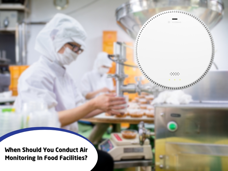 Air monitoring device in a food facility with workers in protective gear maintaining hygiene and safety.