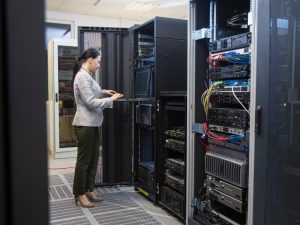 Technician performing air quality tests in a server room with data servers.