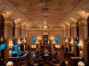 A luxurious hotel lobby featuring elegant chandeliers and decor showcasing the importance of an indoor air pollution monitor.